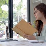 Concentrated female student busy studying using laptop make note