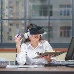 Young girl wearing VR glasses and taking notes